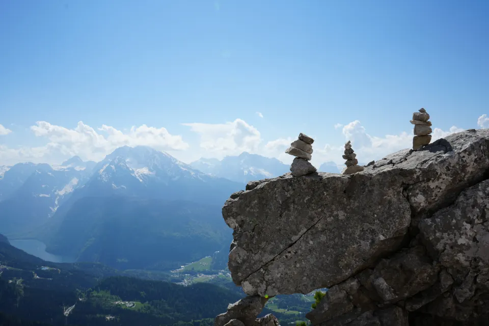 Steinmännchen auf einem Felsen, Aussicht auf die Alpen