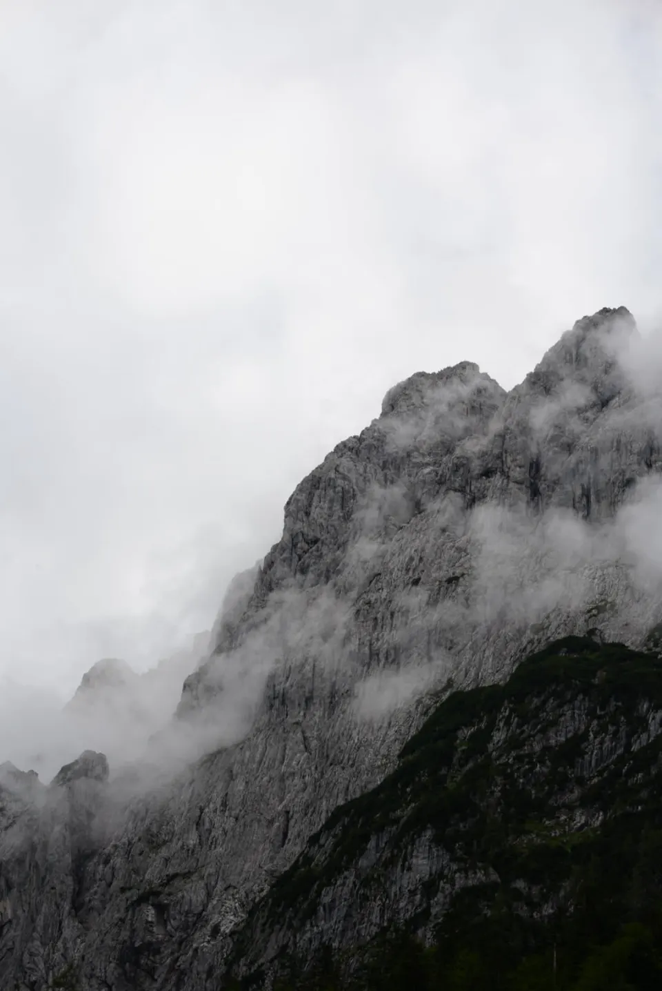 Felsgipfel in Wolken, Hochformat