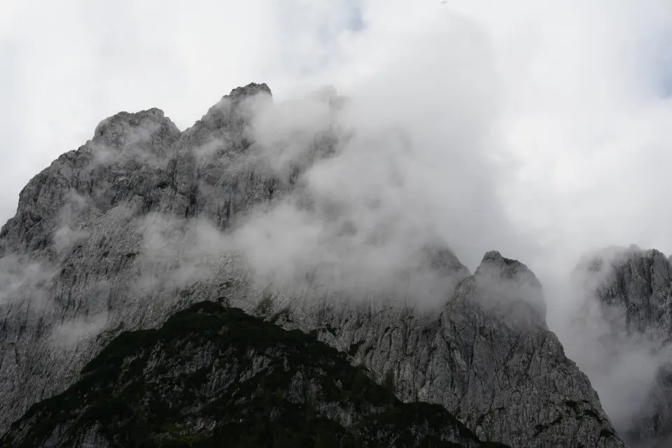 Nebel und Wolken an schroffen Berggipfeln, schwarz-weiß